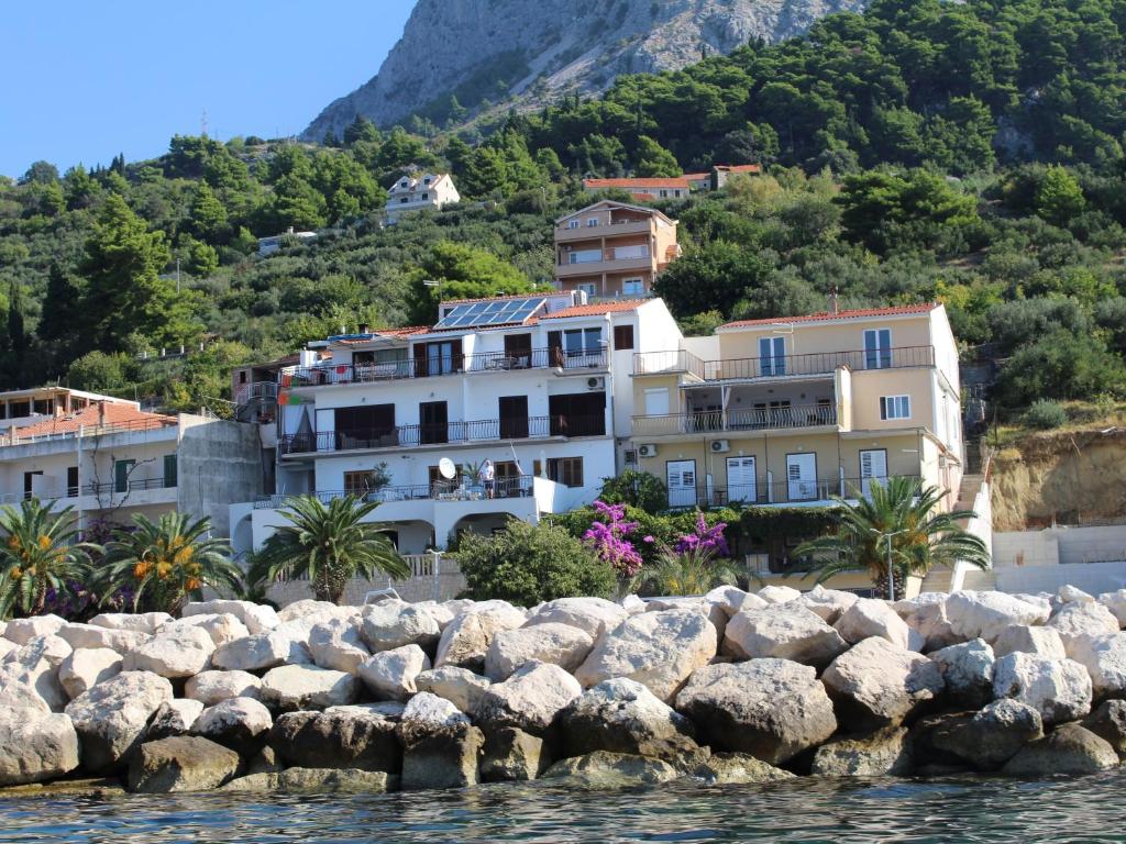un groupe de maisons sur une colline à côté de l'eau dans l'établissement Apartments by the sea Podgora, Makarska - 21378, à Podgora