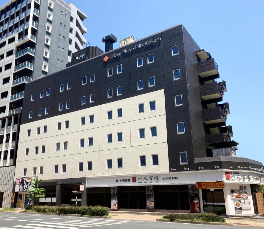 un edificio en una calle con dos edificios altos en Urban Place Inn Kokura, en Kitakyushu