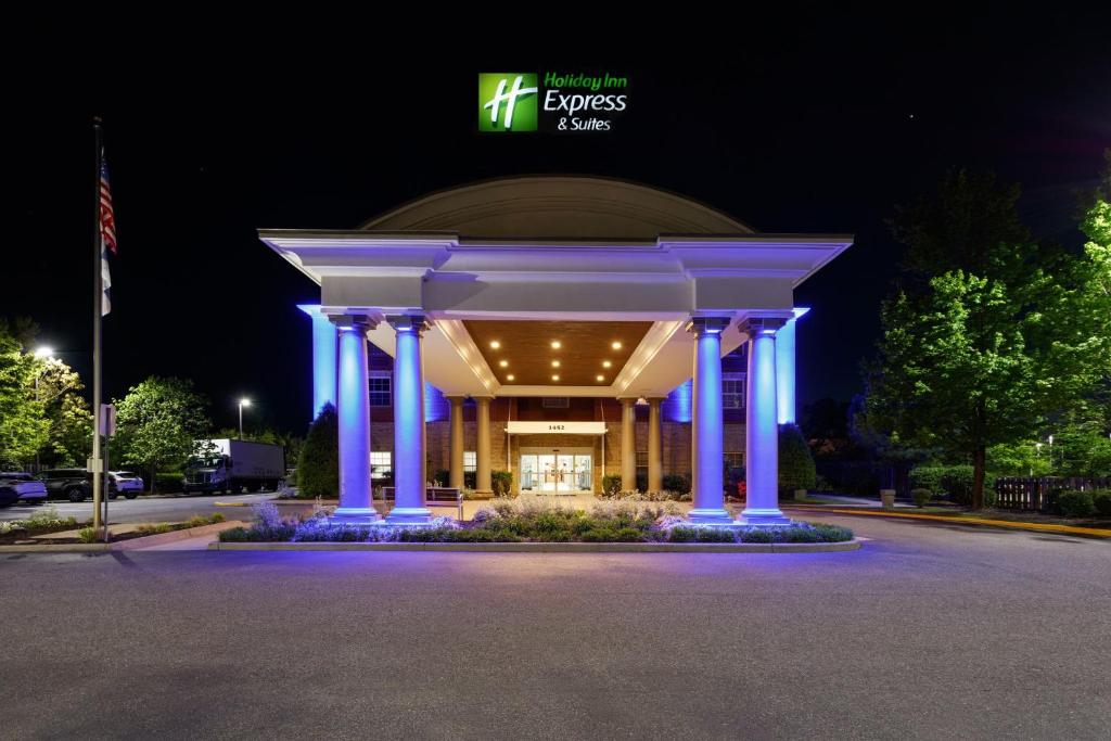 Holiday Inn Express & Suites Williamsburg, an IHG Hotel في وليامزبورغ: مبنى أمامه مصابيح زرقاء