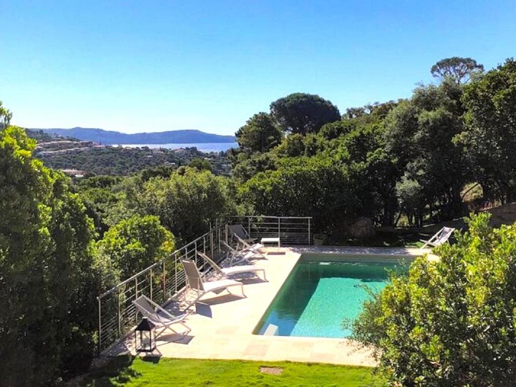 basen z krzesłami i widokiem na ocean w obiekcie Holiday home with swimming pool w mieście Cavalaire-sur-Mer