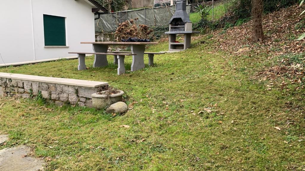 two benches sitting in the grass next to a building at Villetta/5Rent in Muzzano