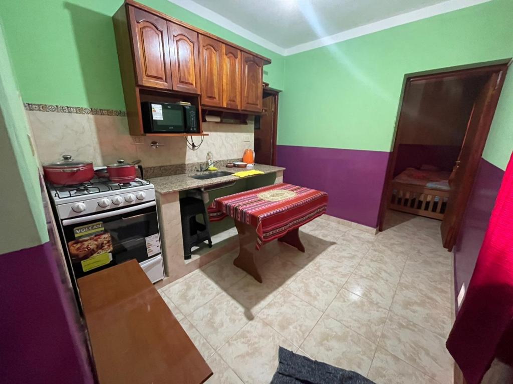 a kitchen with green and purple walls and a stove at CANGO in Humahuaca