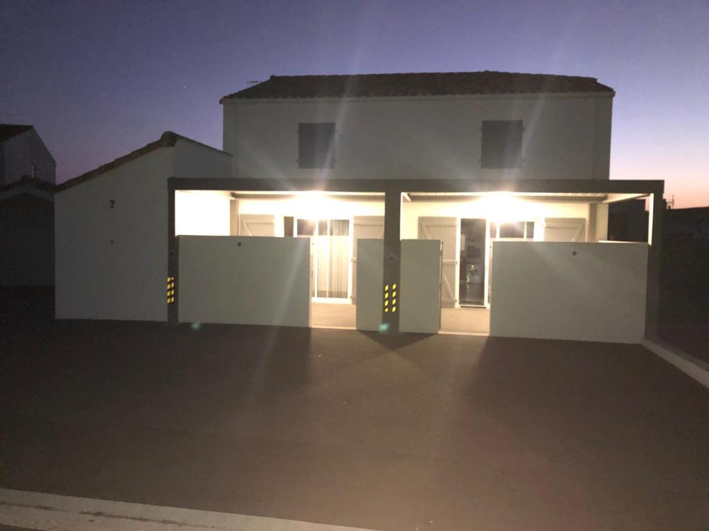 une maison blanche avec des lumières à l'avant dans l'établissement Maison La Tranche-sur-Mer, 3 pièces, 4 personnes - FR-1-22-298, à La Tranche-sur-Mer