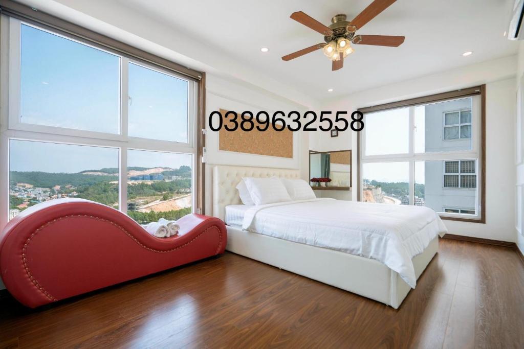 um quarto com uma cama grande e uma cadeira vermelha em Homestay Hạ Long 3 phòng ngủ view biển em Ha Long