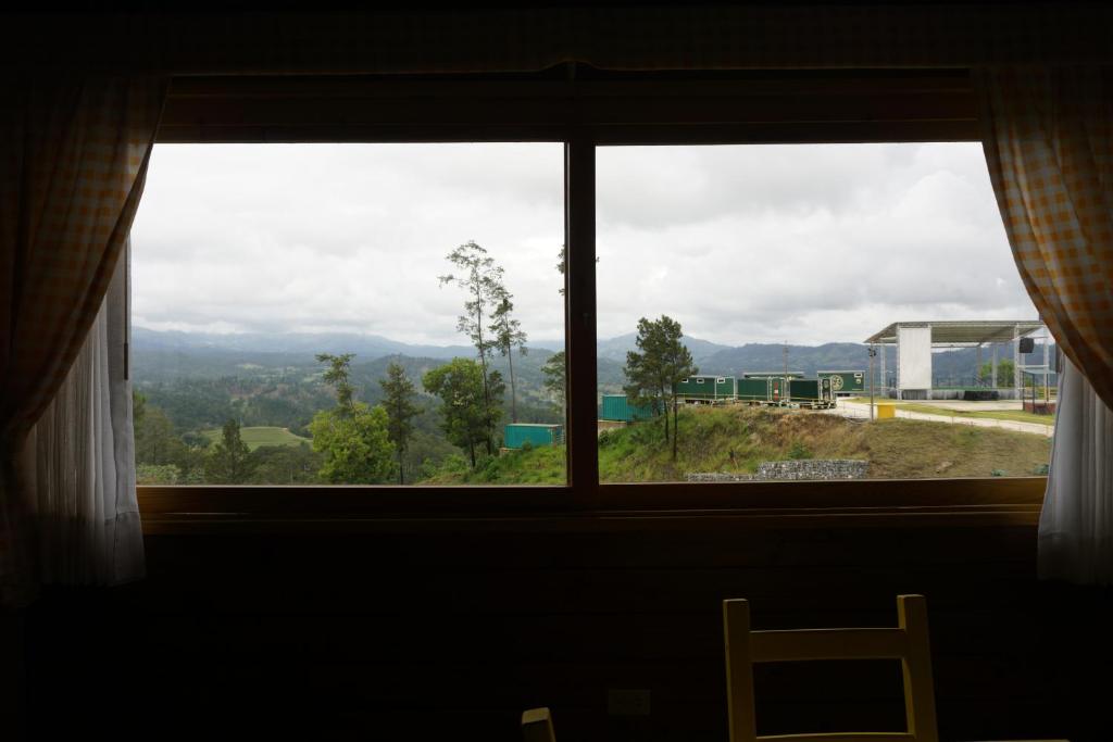 a window with a view of a mountain view at The Woods By Celebration in Jarabacoa