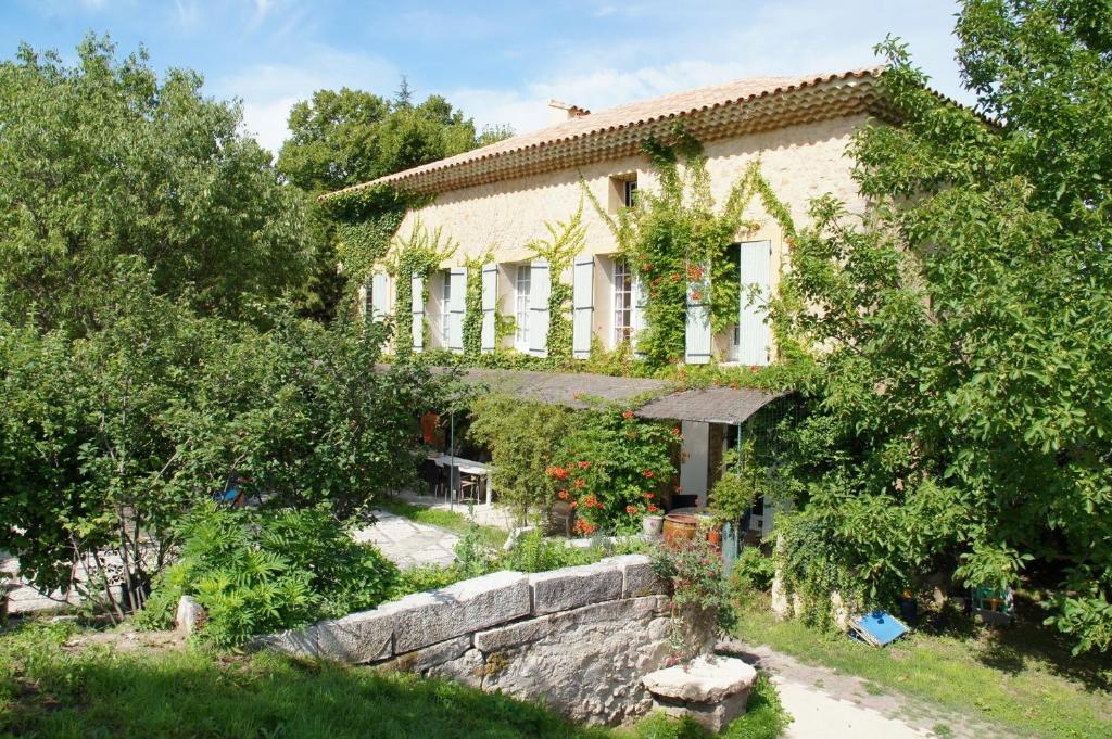 una casa con una pared de piedra delante de ella en Moulin d'Antelon B&B en Crillon-le-Brave