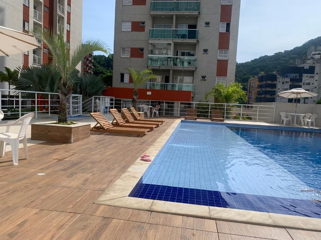 ein Schwimmbad auf dem Dach eines Gebäudes in der Unterkunft Apartamento Guarujá Lazer completo Villa Di Fiori 600mts da praia in Guarujá