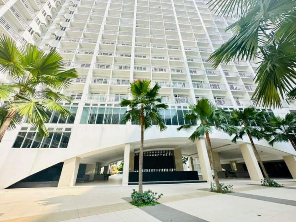 a large building with palm trees in front of it at 1 bedroom unit condo in Manila