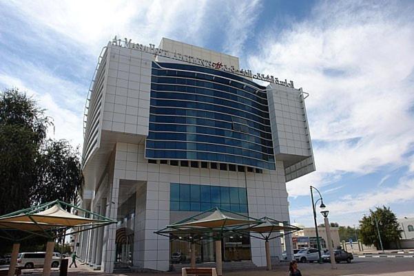 a tall building with people sitting on top of it at Al Massa Hotel Apartments 1 in Al Ain