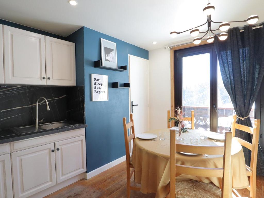 une cuisine et une salle à manger avec une table et une fenêtre dans l'établissement Les Gets - T2 avec parking et vue montagne - FR-1-623-304, aux Gets