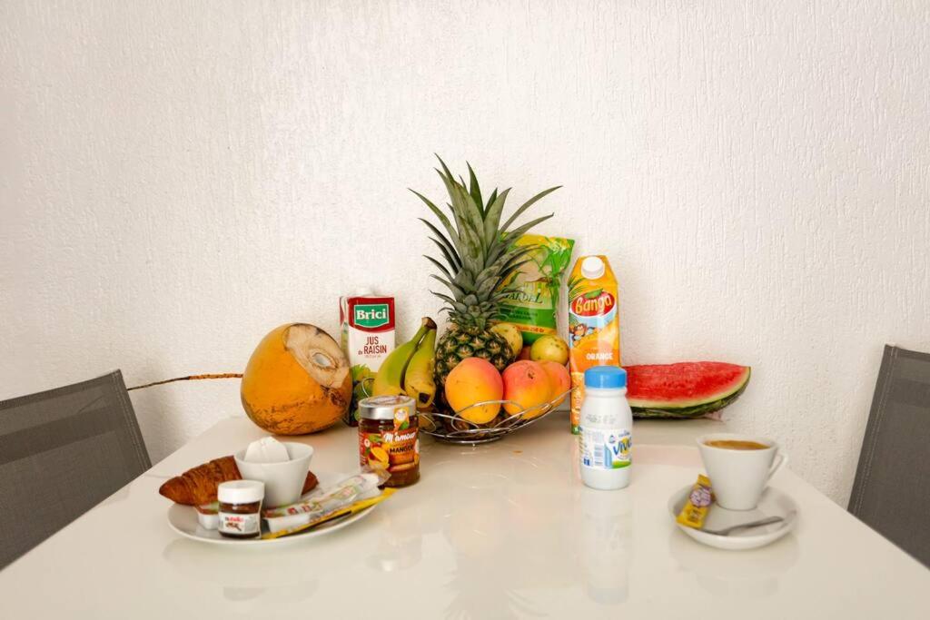 a table with a bowl of fruit and a bowl of nuts at Paradis studio & plage à 1 min in Le Gosier