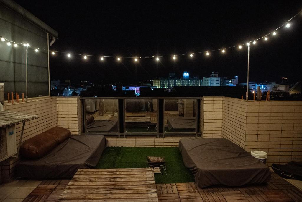 a rooftop patio at night with lights at Bare Foot Diving Hostel 2 in Hengchun