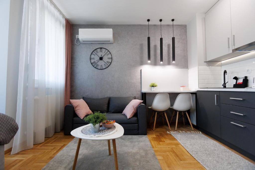 een woonkamer met een bank en een tafel bij Apartman Tija 3 in Subotica