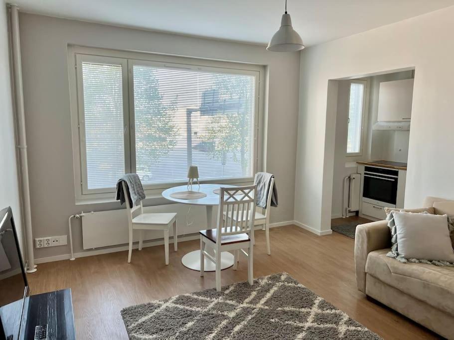 een woonkamer met een tafel en stoelen en een bank bij Apartment Kustaa in Kokkola
