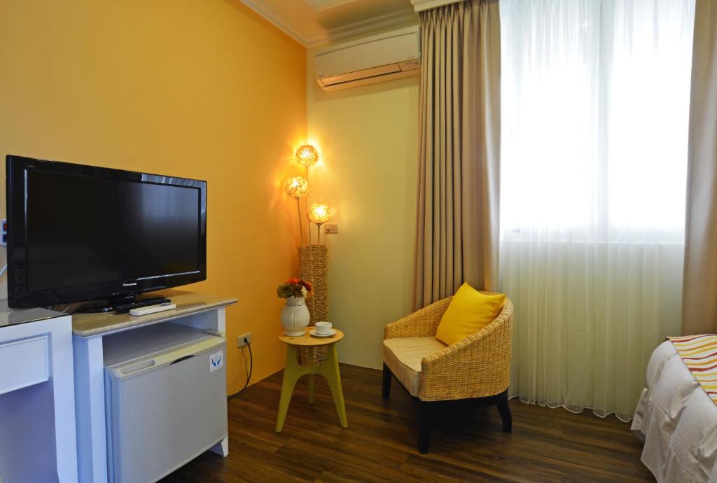 a hotel room with a television and a chair at Yunju House in Jiaoxi