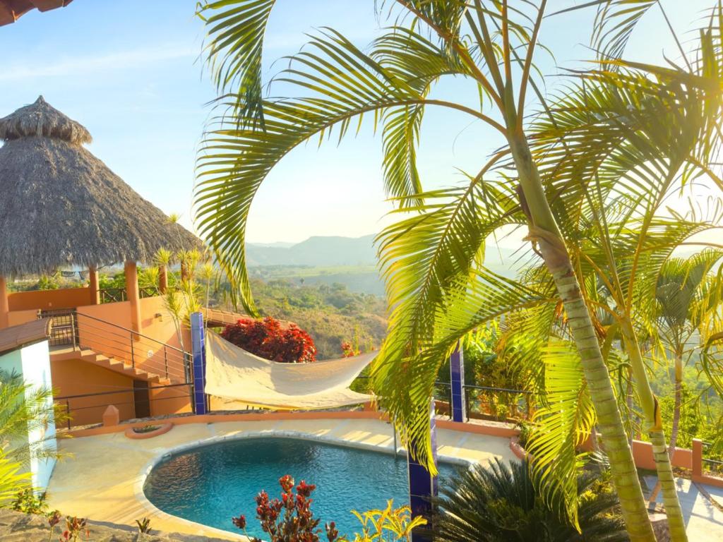 a resort with a swimming pool and a palm tree at Cerrito Encantado! Hidden Escape with Amazing Views 