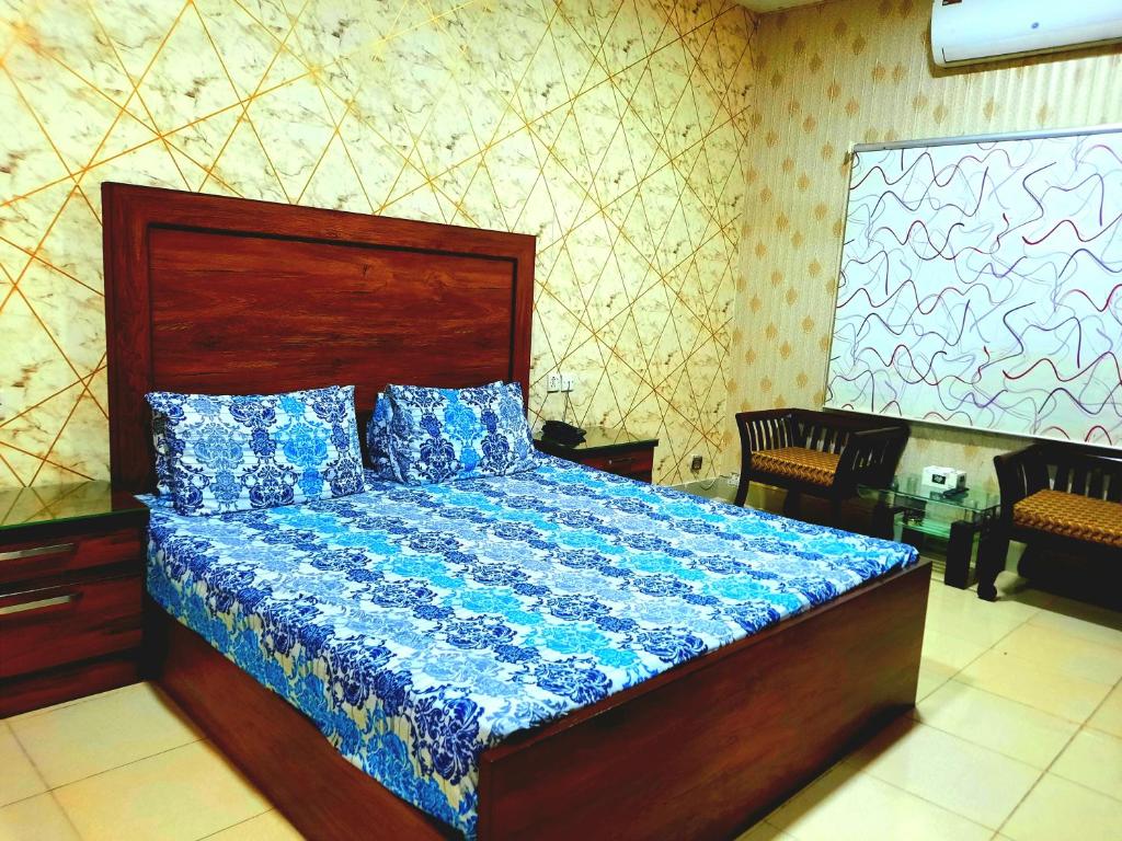 1 dormitorio con 1 cama con edredón azul en Best Couple Coprtive Guest House en Karachi