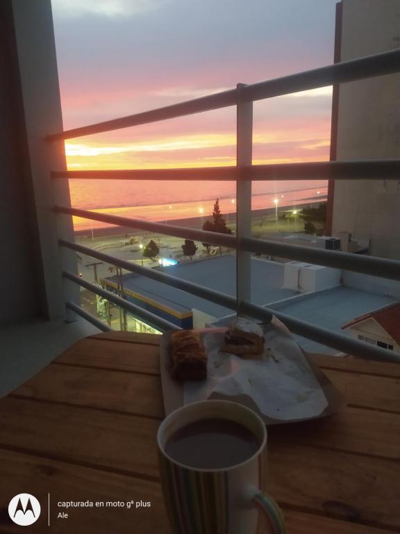 una mesa con un plato de comida y una taza de café en whales&beach en Puerto Madryn