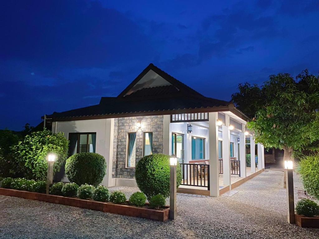 ein Haus mit beleuchteter Fassade in der Nacht in der Unterkunft Sanaepatan Home Resort - เสน่ห์ป่าตาล โฮม รีสอร์ต in Ban Buak Khang