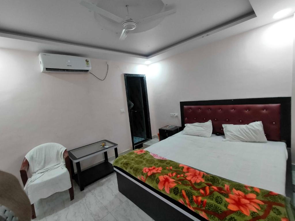 a hotel room with a bed and a chair and a bed sidx sidx at OYO 81285 Hotel Chanda in Madhubani