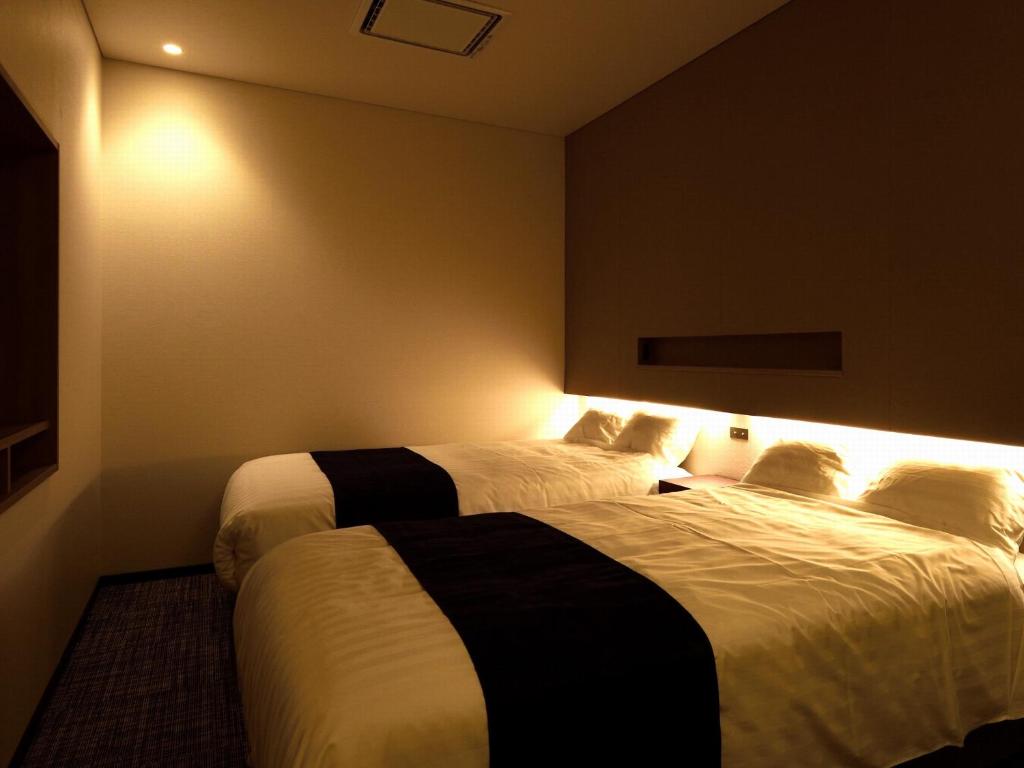 Habitación de hotel con 2 camas con luces. en みくに隠居処, en Sakai