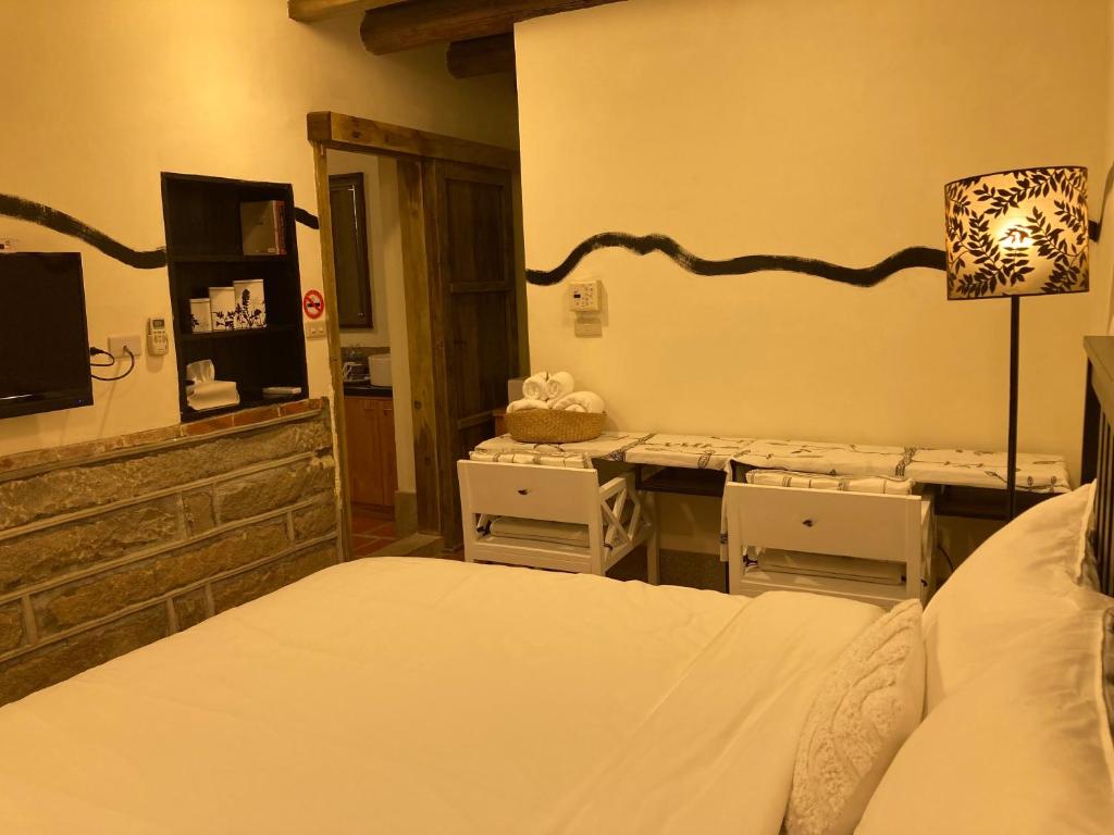 a bedroom with a bed and a table with chairs at Shenten Homestay in Jincheng