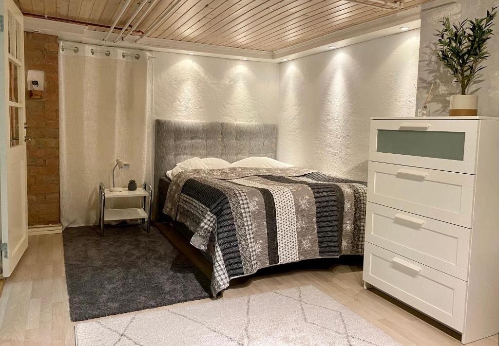um quarto com uma cama e uma cómoda em Lower floor of 50 sqm in nice villa with parking em Estocolmo