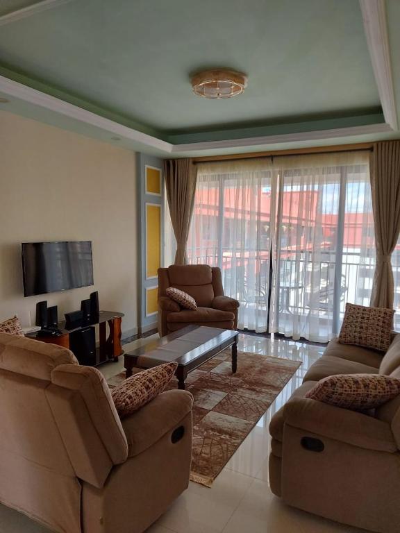 ein Wohnzimmer mit 2 Sofas und einem TV in der Unterkunft the heavenly apartments along Dennis prit road. in Nairobi