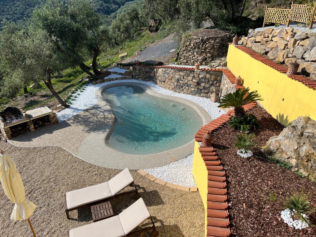 uma pequena piscina num quintal com cadeiras em Casale tra gli Ulivi em Diano San Pietro