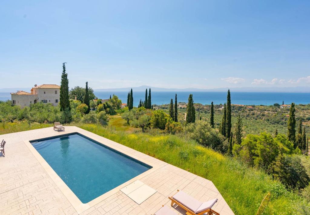 - une piscine dans un jardin avec vue sur l'océan dans l'établissement Villa Sadova Private pool Panoramic view, à Kalamata