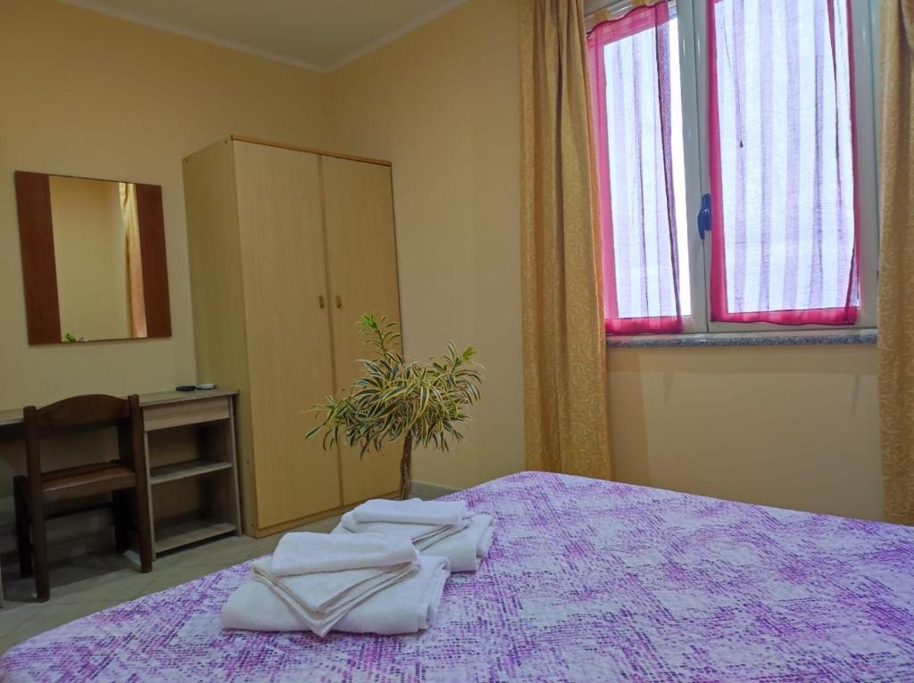 een slaapkamer met een paars bed met handdoeken erop bij TropeaCharmet PARKING FREE in Tropea