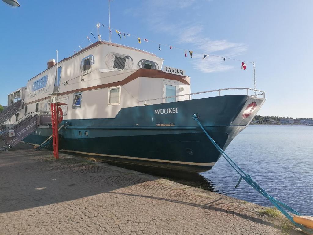 ein blaues und weißes Boot im Wasser angedockt ist in der Unterkunft Hotellilaiva Wuoksi in Kuopio