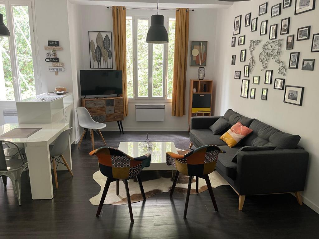 een woonkamer met een bank en een tafel en stoelen bij Chez angy et manu in Marseille