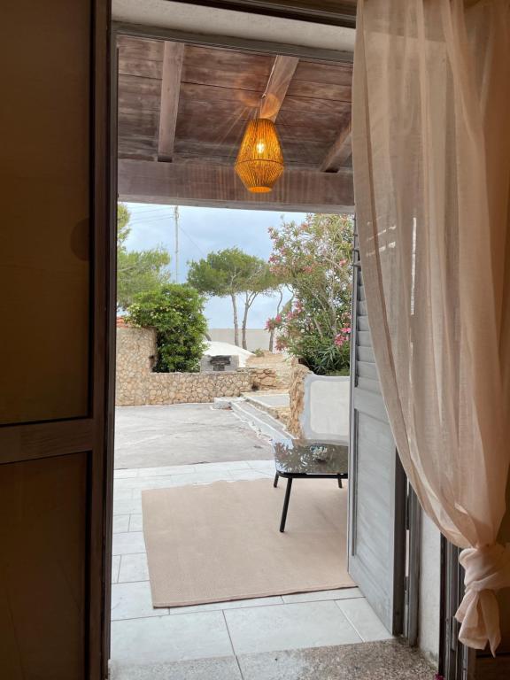 eine Tür zu einer Terrasse mit Meerblick in der Unterkunft B H Lampedusa in Lampedusa