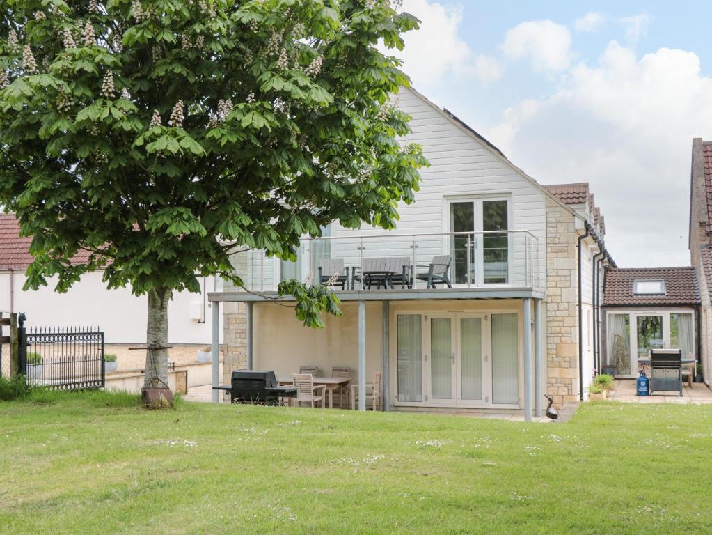 a house with a patio and a tree at The Winning Post in Bruton