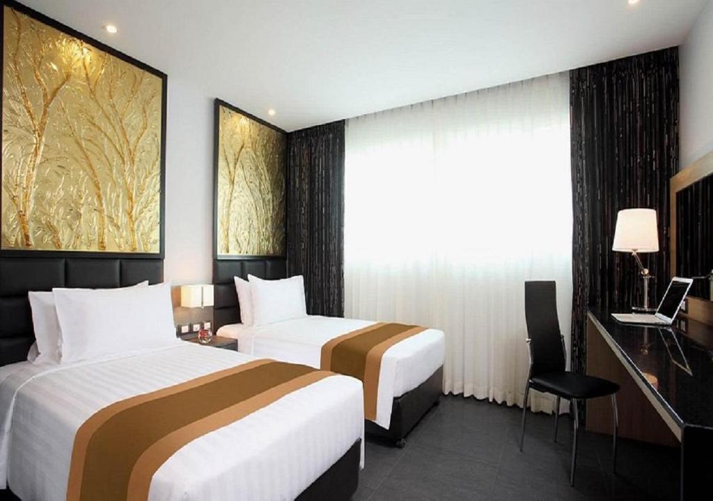 Postel nebo postele na pokoji v ubytování Nova Express Pattaya Hotel