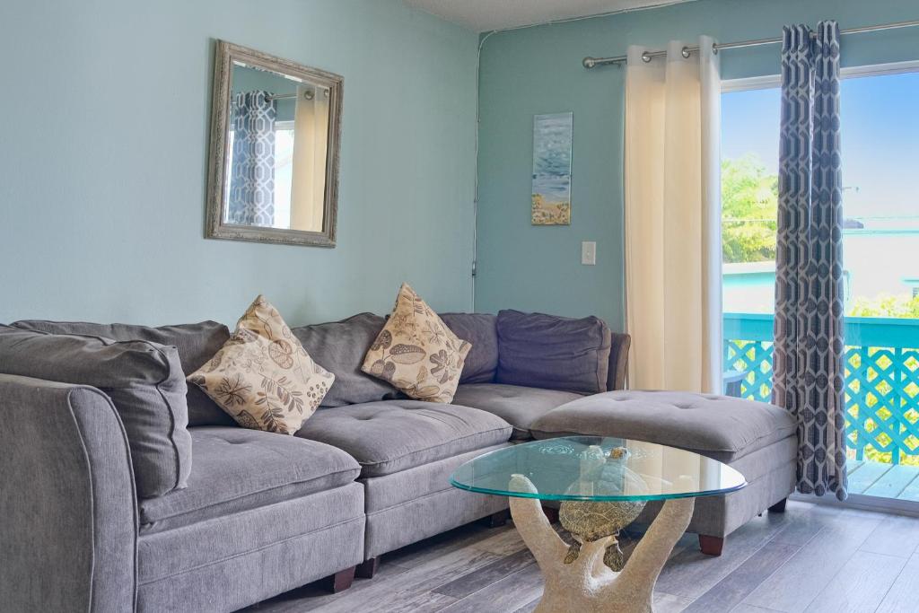 ein Wohnzimmer mit einem Sofa und einem Glastisch in der Unterkunft Bungalow E in Bradenton Beach
