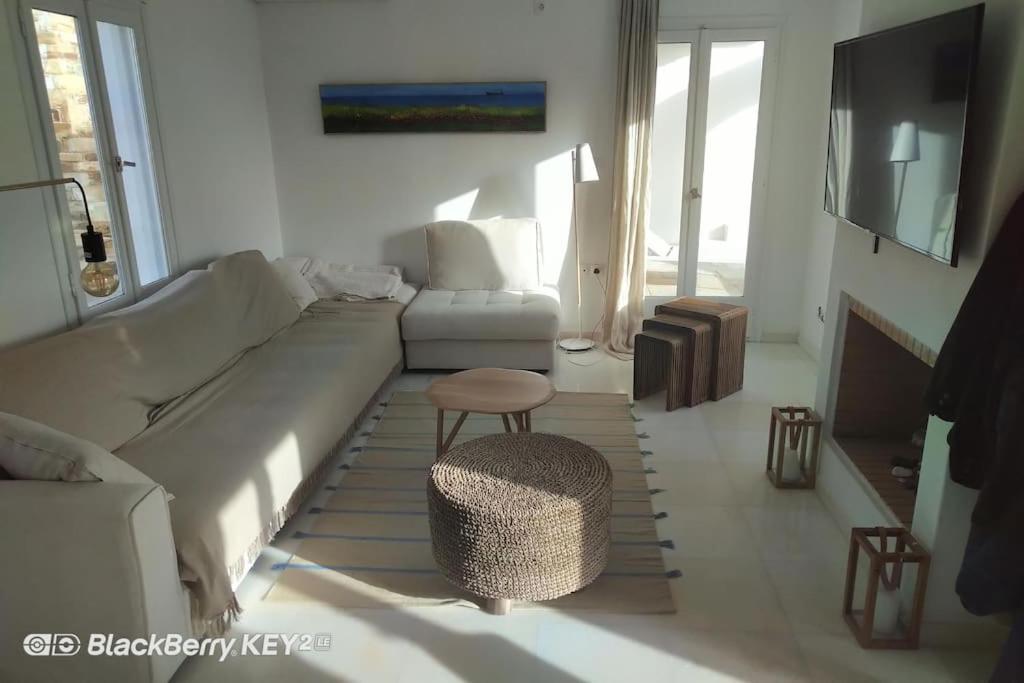 - un salon avec un canapé, une chaise et une table dans l'établissement Cyclades, villa surplombant la mer, à Ios Chora