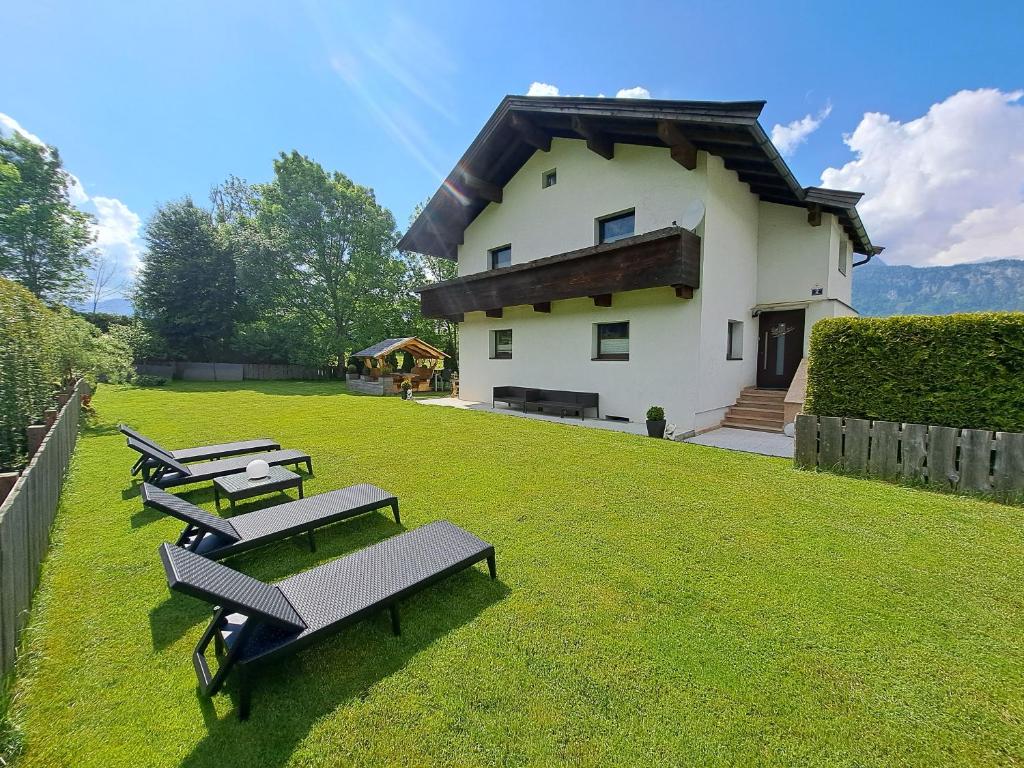 a group of benches sitting on the grass in front of a building at Haus Milan in Sankt Johann in Tirol