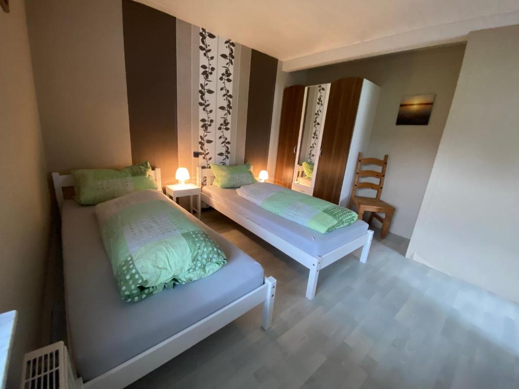 a bedroom with two beds and a table and chairs at Ferienwohnung Ulmbach -Sterntaler- in Steinau an der Straße