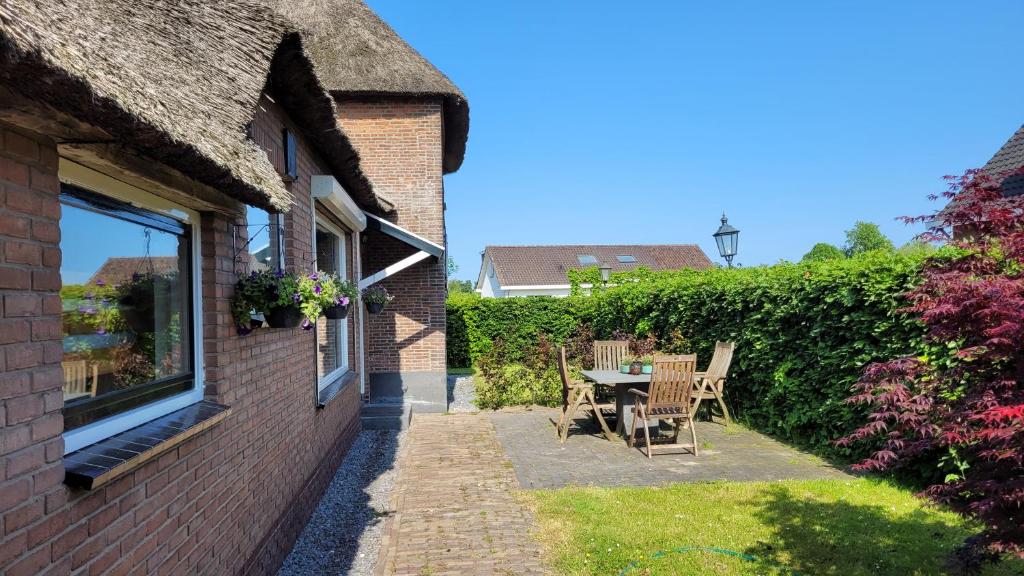 een patio met een tafel en stoelen naast een gebouw bij Betuwe Huisje in Meteren