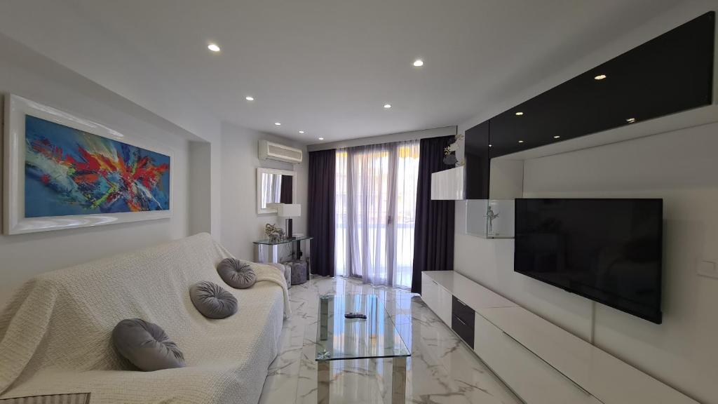 a living room with a white couch and a flat screen tv at Apartamento Edificio Astoria in Benidorm
