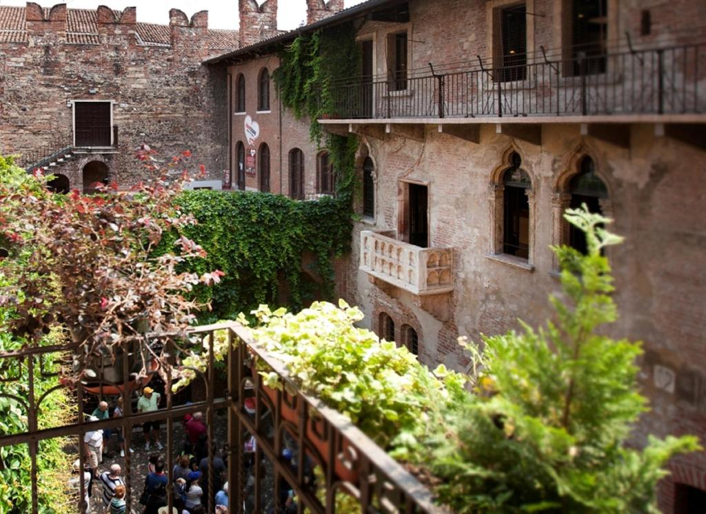 eine Gruppe von Personen, die außerhalb eines Gebäudes stehen in der Unterkunft Relais Balcone di Giulietta in Verona