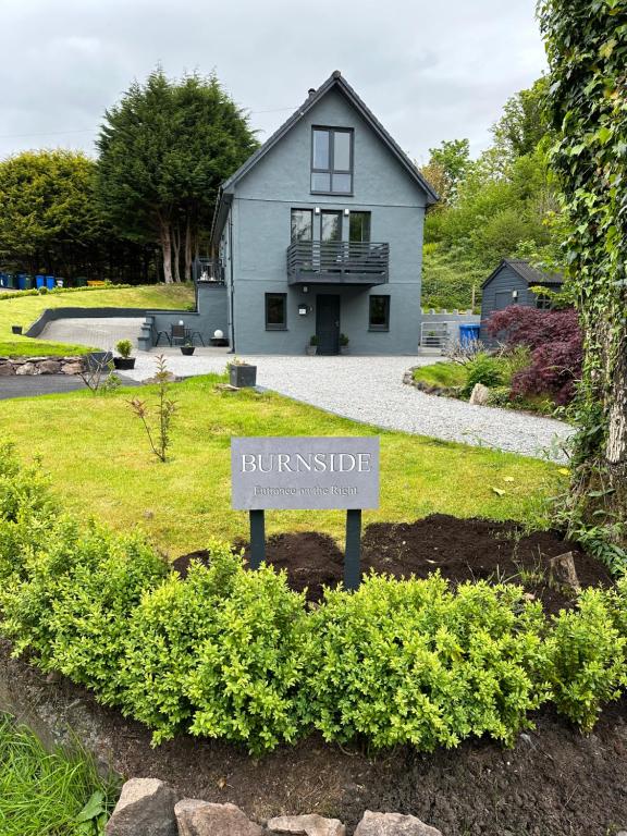 a house with a sign in front of a yard at Burnside in Oban