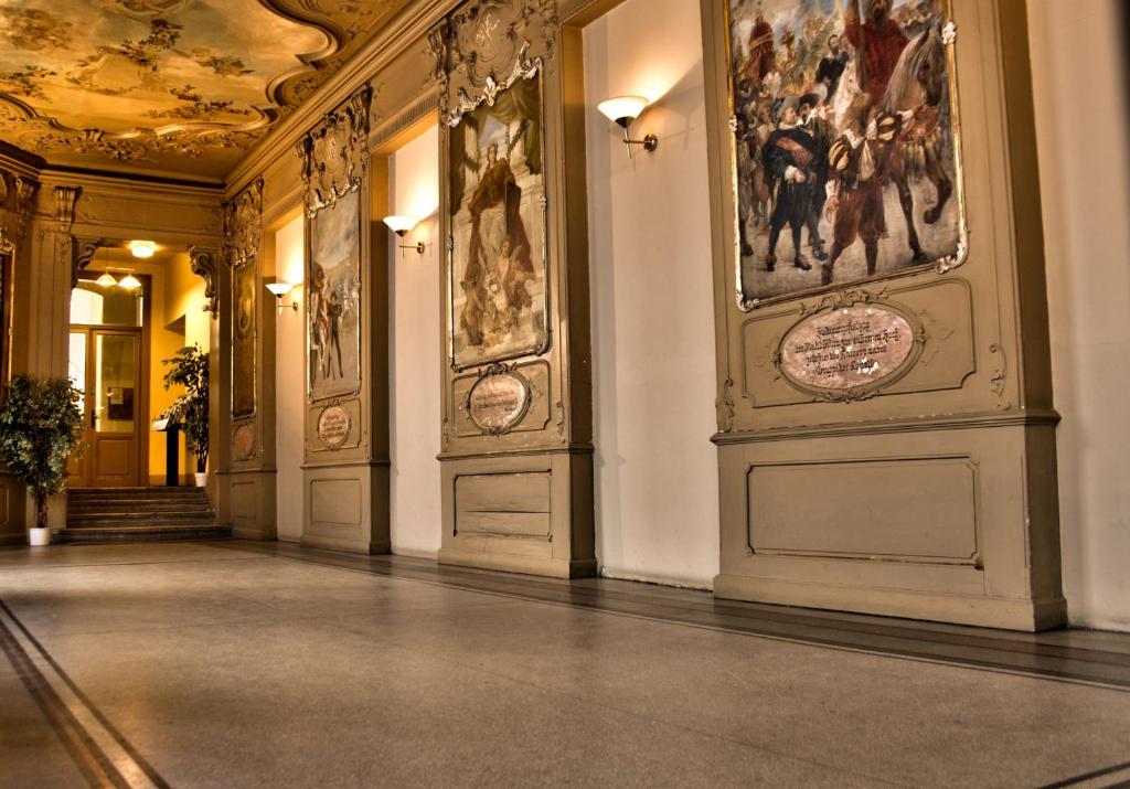 a hallway with paintings on the walls of a building at Self Check-in Hotel Am Schottenpoint in Vienna