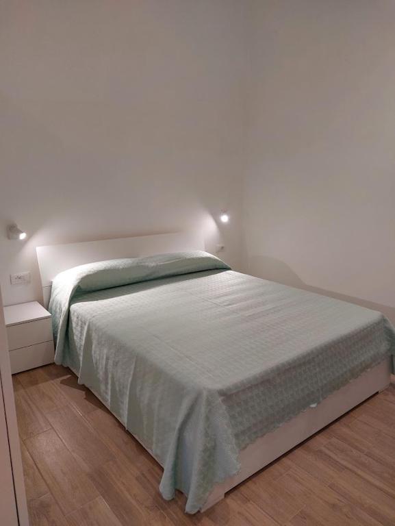un letto in una camera da letto con parete bianca di Piccolo Borgo a Ischia