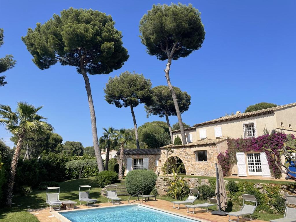 a villa with a swimming pool and palm trees at Magnifique Villa de prestige Antibes/Juan-les-Pins in Antibes