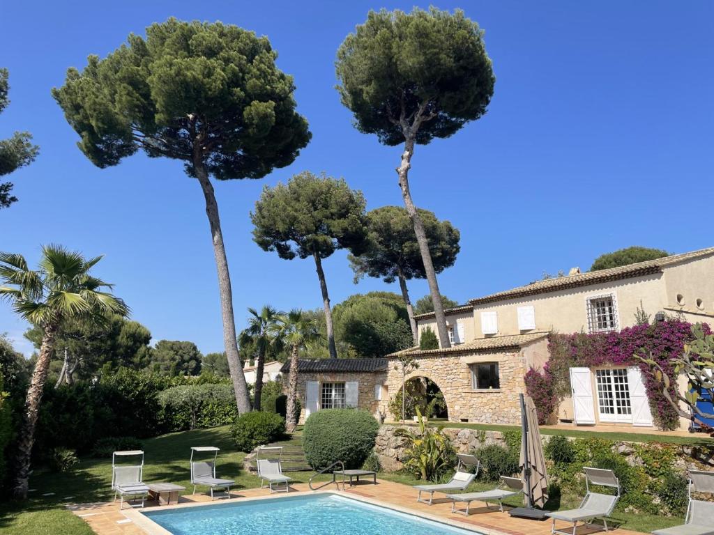 une villa avec piscine et palmiers dans l'établissement Magnifique Villa de prestige Antibes/Juan-les-Pins, à Antibes