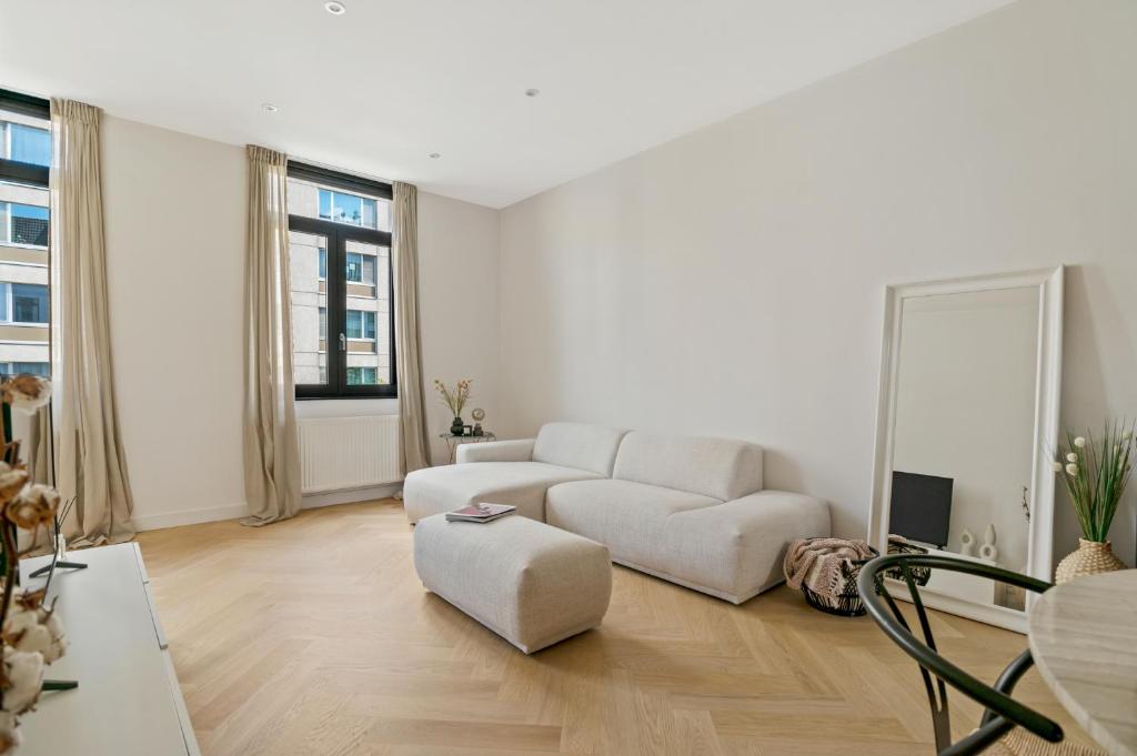 uma sala de estar branca com um sofá e uma cadeira em Zuid's Charming Gem Apt em Antuérpia