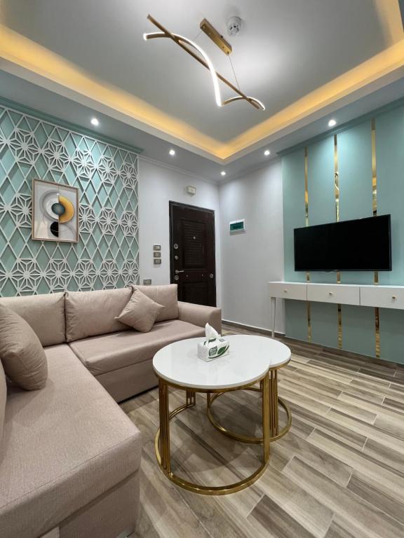 ein Wohnzimmer mit einem Sofa und einem TV in der Unterkunft BS Lodging 15 - Next to Dream Beach in Hurghada